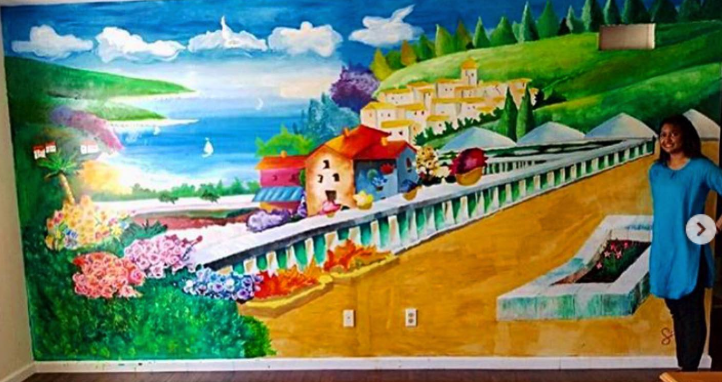 Colorful Mediterranean coastal village mural painted across an interior wall