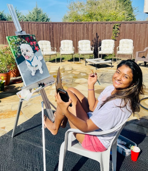 Artist painting a white dog portrait outdoors